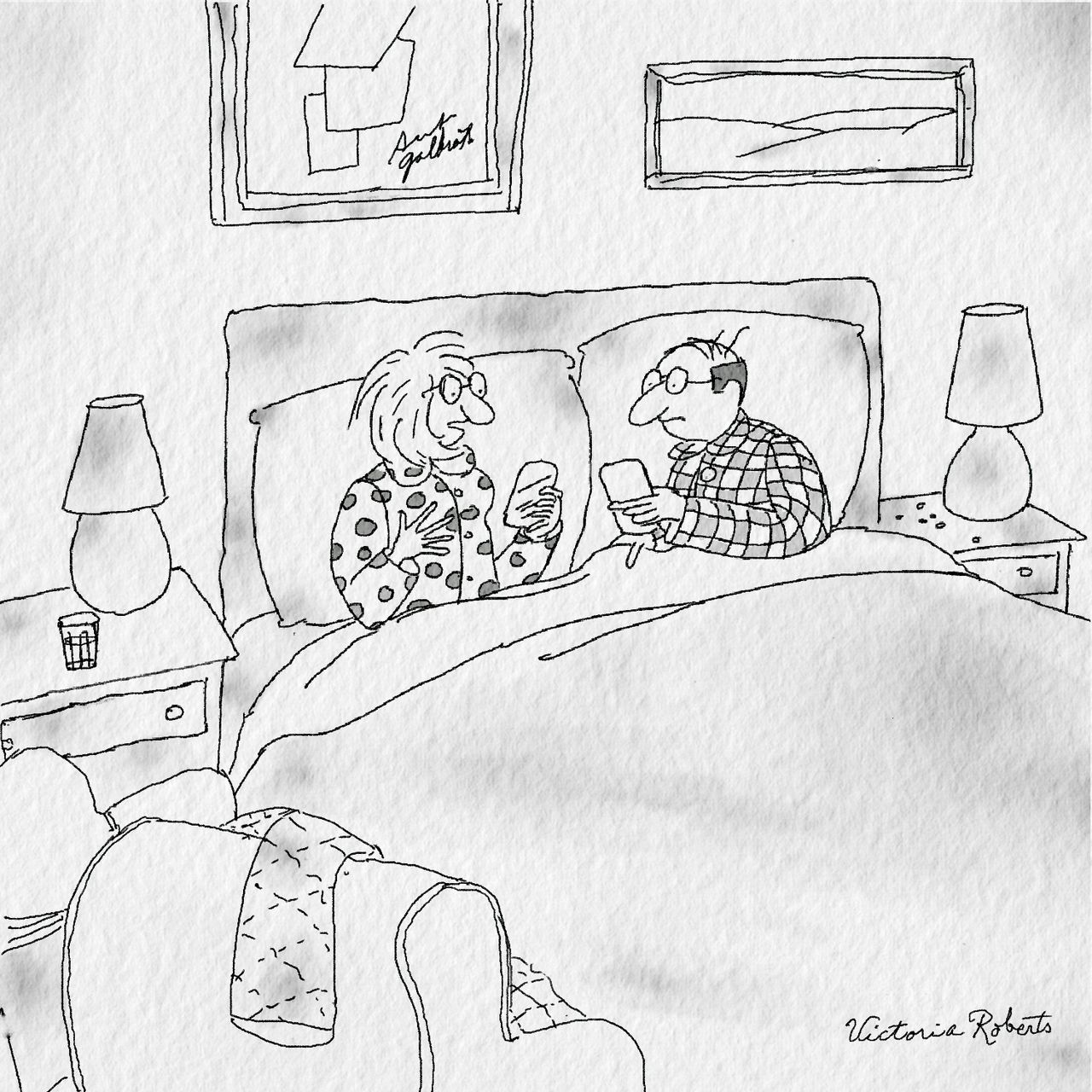 Two people sit in bed looking at their smartphones.